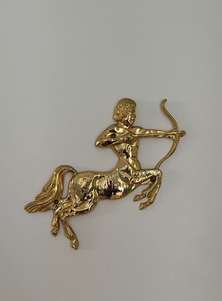 a gold brooch depicting a horse with a human figure on it's back