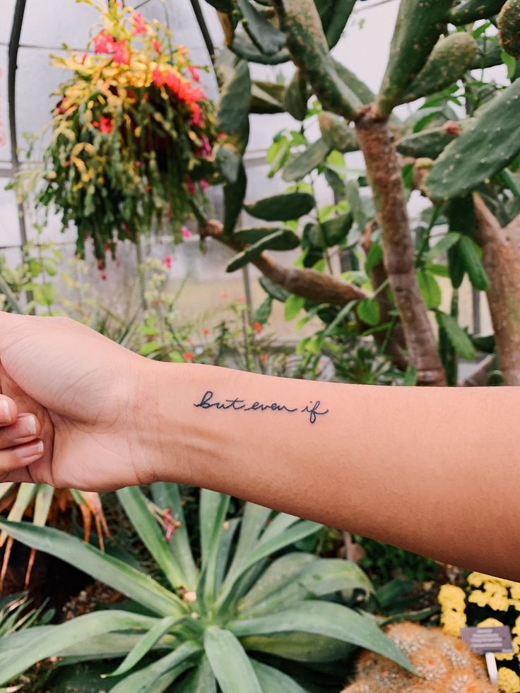 a person holding the hand of another person with a tattoo on their arm that reads, batonine i