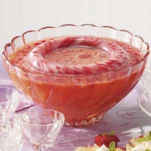 a glass bowl filled with liquid sitting on top of a table next to some fruit