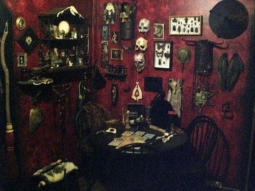 black and white photograph of a dining room with many pictures on the wall, including skulls