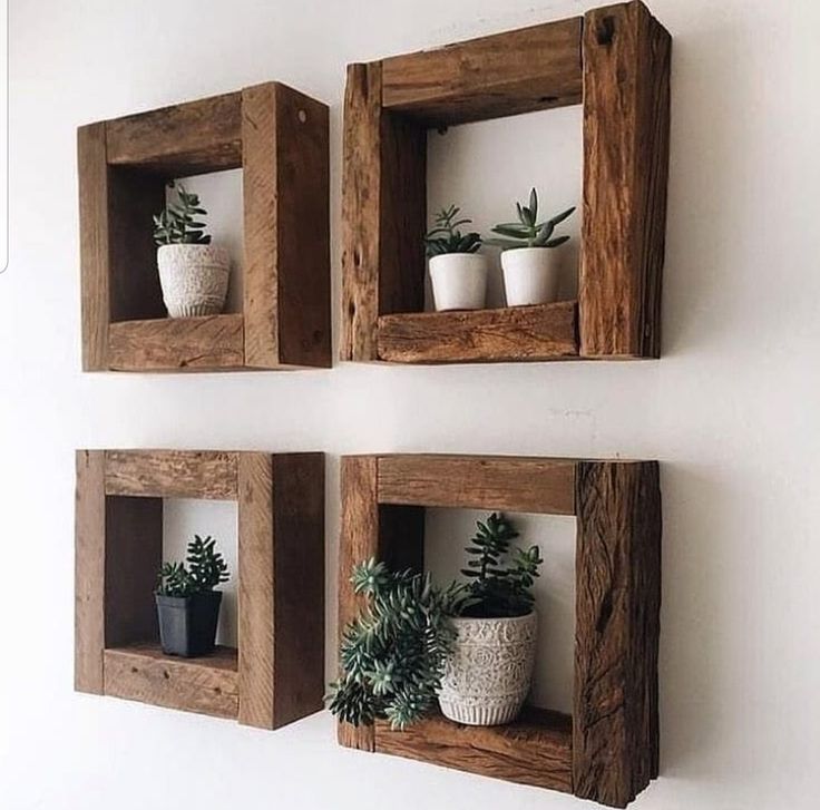 three wooden boxes with plants in them on the wall