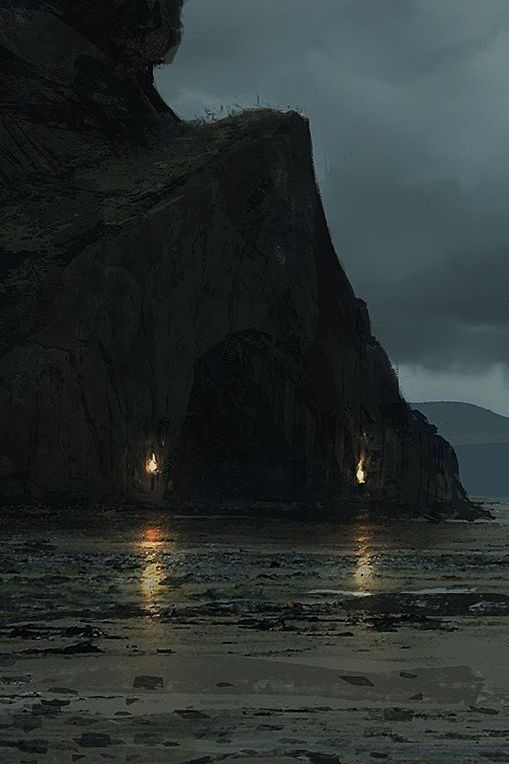 two people are standing on the beach at night