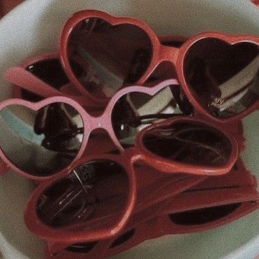 some heart shaped sunglasses are in a bowl