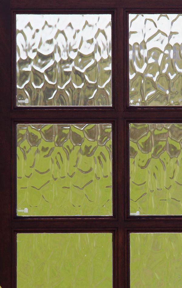 a window with rain drops on it and a yellow vase sitting in the window sill