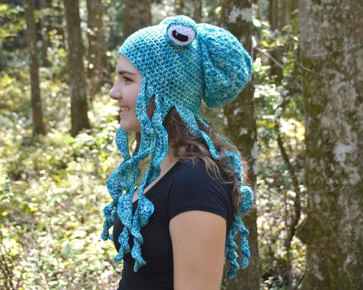 a woman wearing a crocheted octopus hat in the woods