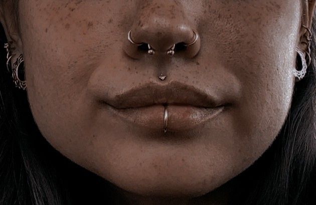 a woman with piercings on her nose and nose ring