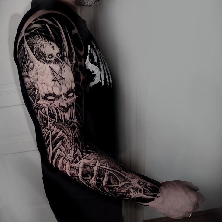 a man with a black and grey tattoo on his arm