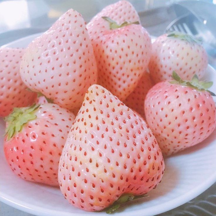 a white plate topped with lots of ripe strawberries