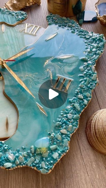 a clock made out of sea glass on top of a wooden table next to other items