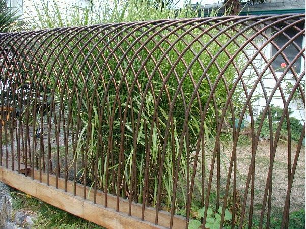 a metal fence that has some plants growing out of it