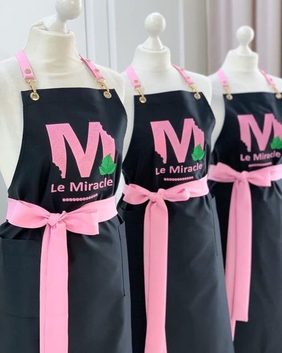 three black aprons with pink bows on them and the words le mirade written in french