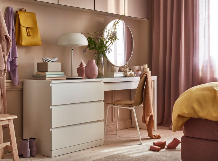 a bedroom with a dresser, mirror and shoes on the floor in front of it