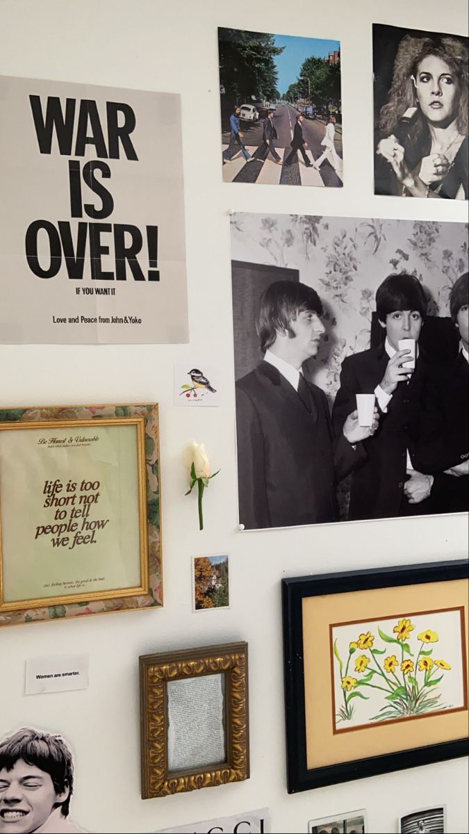 the wall is covered with pictures and framed photos, which include beatles's famous album covers