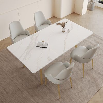 an aerial view of a dining room table with chairs and a vase on the floor