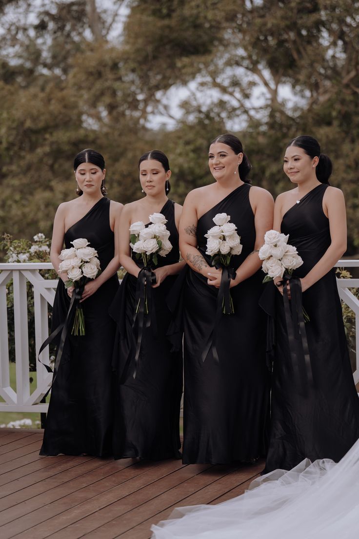 a group of women standing next to each other on top of a wooden floor covered in white flowers