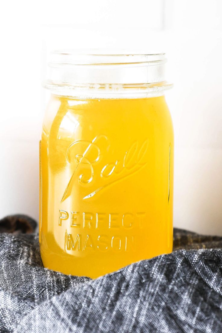 a glass jar filled with liquid sitting on top of a blanket