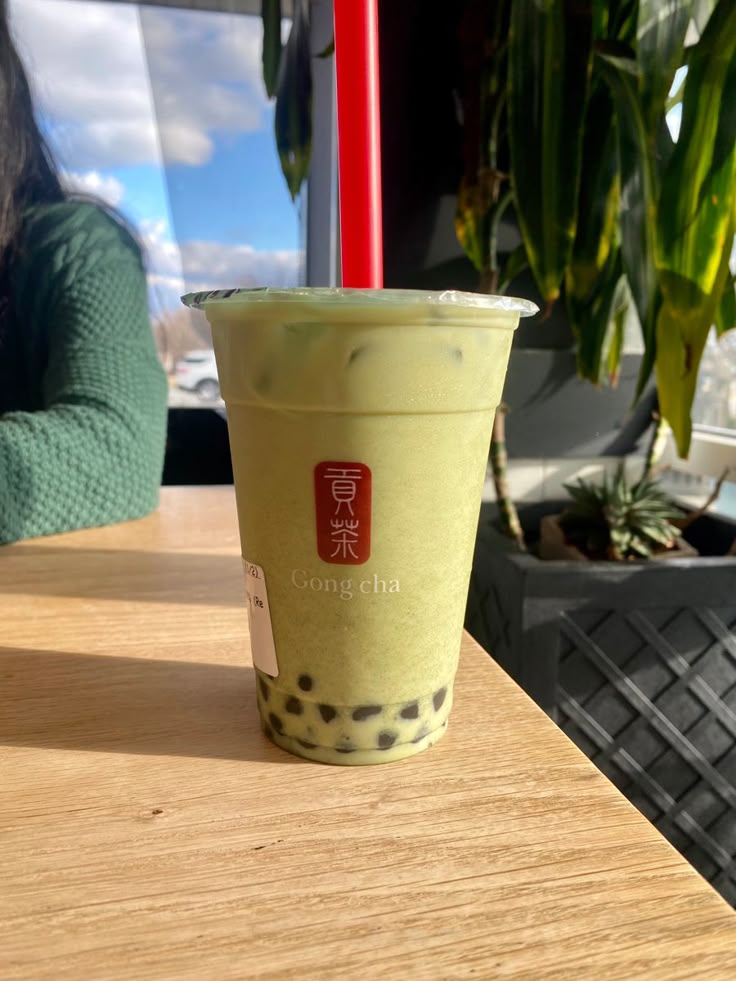 a green drink sitting on top of a wooden table