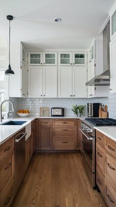 a kitchen with wooden floors and white cabinets