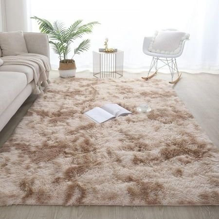 a living room with a couch, chair and rug on the floor in front of a window