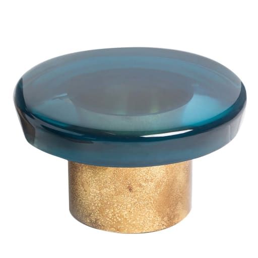 a gold and blue glass knob on a white background