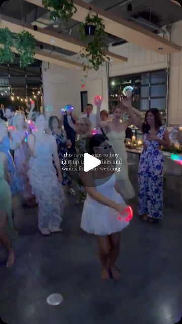 a group of people standing around each other in a room with lights on the ceiling