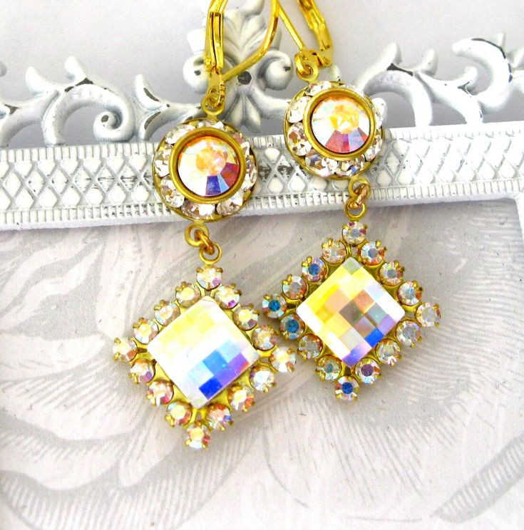 Diamond shaped AB crystal earrings. Sparkling faceted AB Swarovski crystal centered in an AB crystal square. Above - more crystals - Swarovski AB in the center. Incredibly sparkly earrings hung on a gold-plated lever back ear wire.  ஜஜஜஜ Gold plated and crystal earrings - handcrafted and original. I can create more of this style.   Love these AB crystal squares - they reflect whatever I put with them and also the surrounding colors.  ஜஜஜஜ Dangle about 1-1/2 inch overall.  The crystal square is 1 Sparkly Earrings, Swarovski Earrings, Diamond Drop Earrings, Diamond Shaped, Gorgeous Jewelry, Gold Plated Earrings, Jewelry Gold, Ear Wire, Crystal Earrings