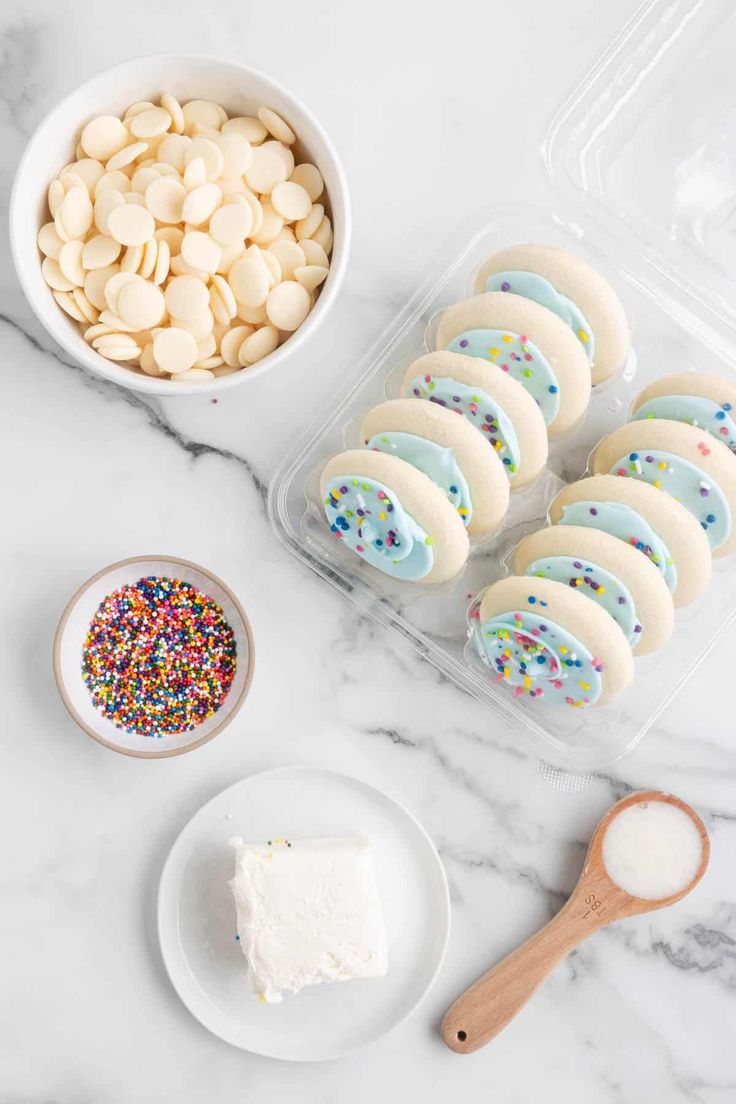 the ingredients to make white chocolate sprinkle cookies are displayed on a marble countertop