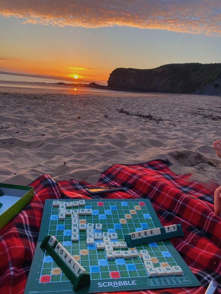 a person sitting on the beach with a board game