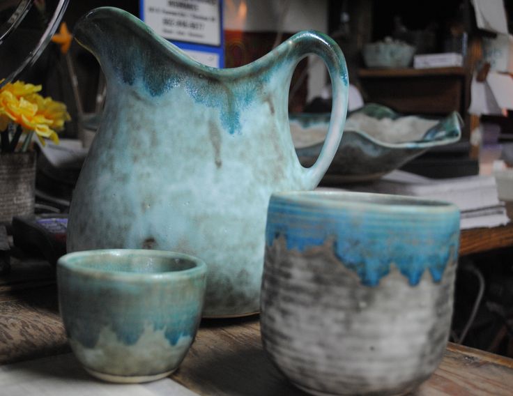 a pitcher and two cups sitting on a table