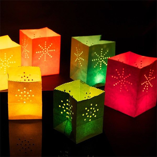 several lit up paper lanterns sitting on top of a black table with one glowing green and the other red