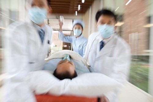 three doctors in white lab coats and face masks are performing an operation on a patient