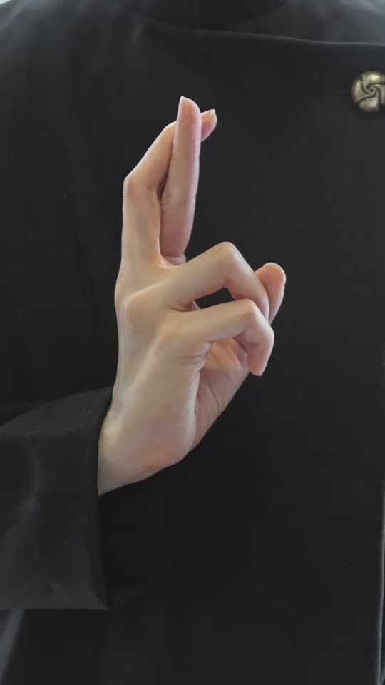 a person wearing a black jacket and holding their fingers together