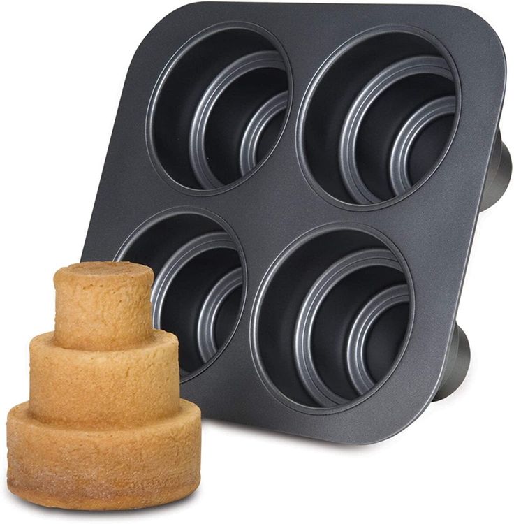 a cake pan with six cupcakes in it next to a wooden holder for the dough