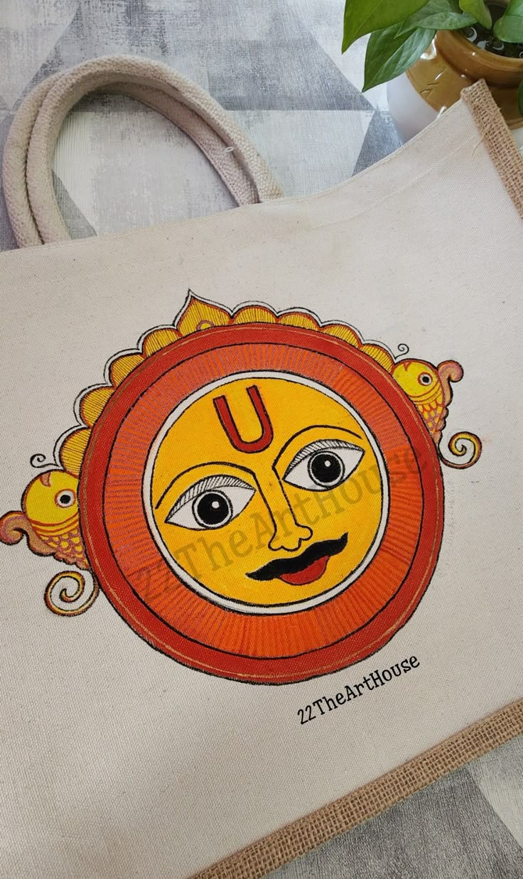 a bag with an image of a sun on the front and side, sitting next to a potted plant