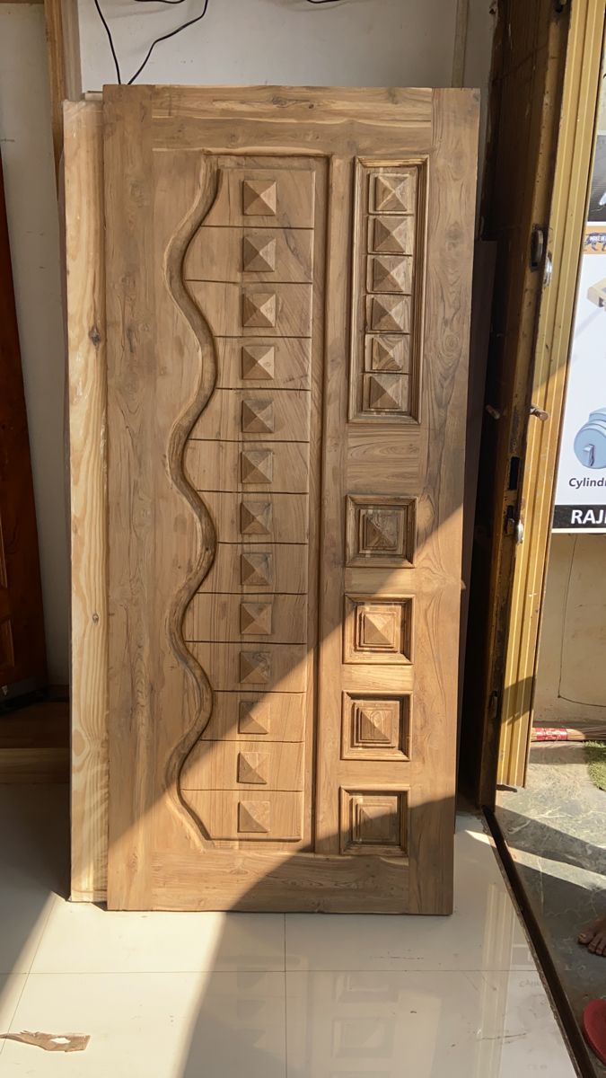 an unfinished wooden door with decorative carvings on it