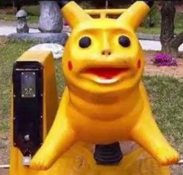 a statue of a yellow cat sitting on top of a parking meter