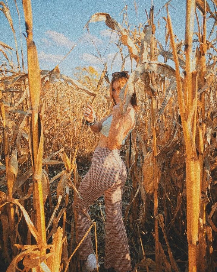 a woman standing in a field of corn