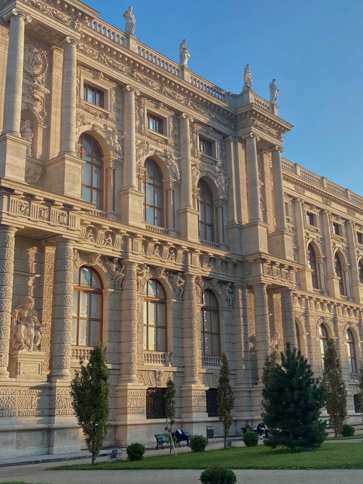 a large building with many windows and statues on the side of it's sides