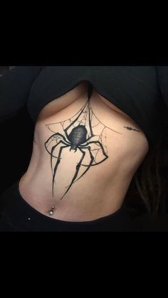 a woman with a spider tattoo on her stomach