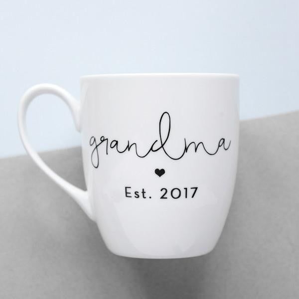 White mug with black grandma text Grandma Cups Vinyl, Coffee Mugs For Grandma, Grandma Coffee Mug Vinyl, Nana Coffee Mug, Corporate Holiday Gifts, Grandma Mug, Mother’s Day Coffee Mugs, New Grandma, Script Lettering