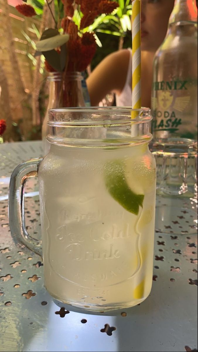 a mason jar filled with lemonade sitting on top of a table