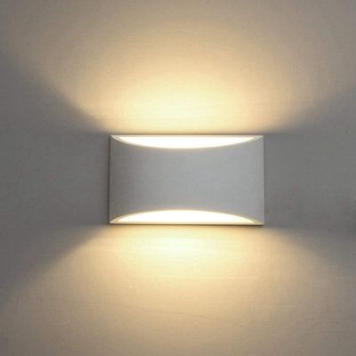 a white wall light that is on the side of a wall with two lights above it