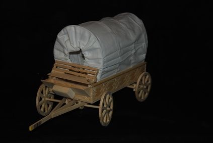 an old wooden wagon with white bags on it's back and wheels, in the dark