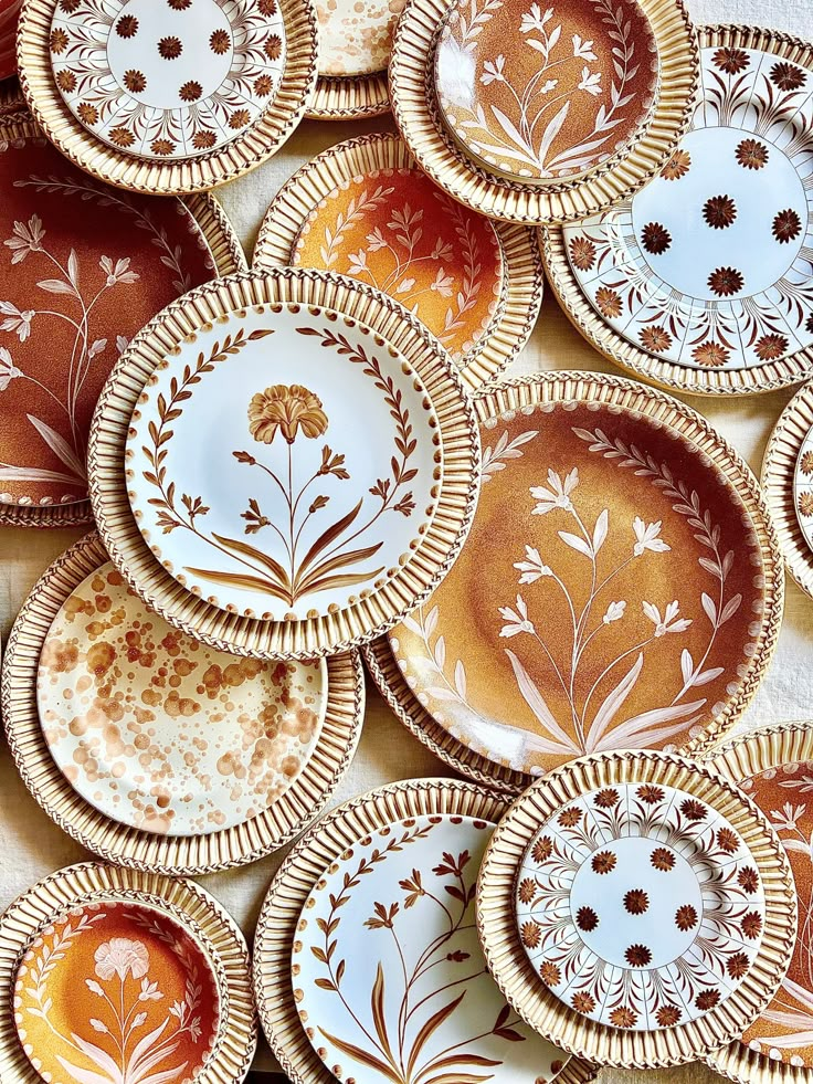 many plates with designs on them are arranged in the shape of flowers and leaves,