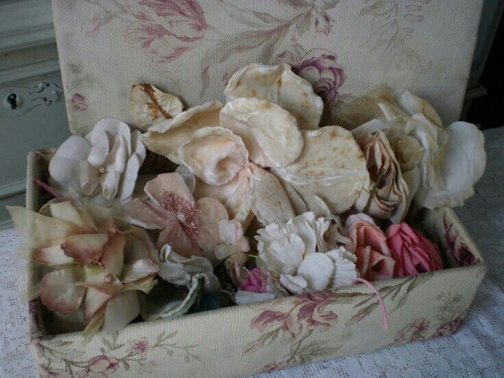 an open box filled with flowers on top of a bed