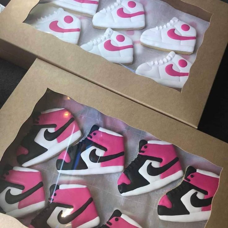 pink and black nike shoes are in a box on the floor next to each other