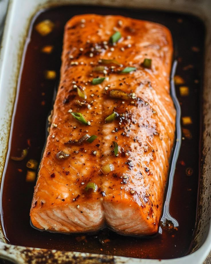 a piece of salmon in a pan with seasoning