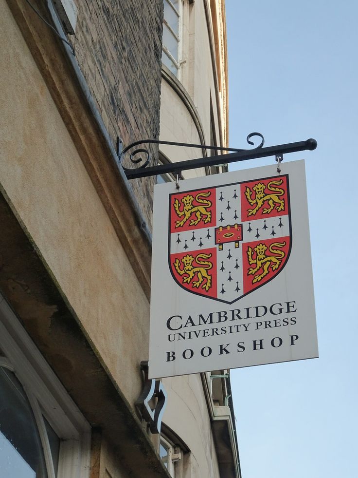 a sign for cambridge university press bookshop hanging from the side of a building