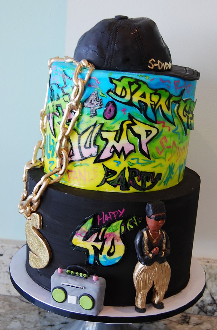 a three tiered cake with graffiti on it's sides and a hat on top