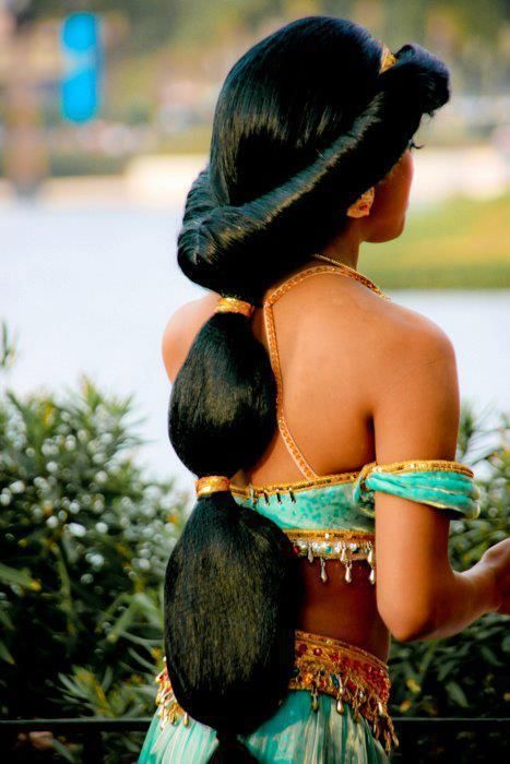 the back of a woman's head with long black hair and braids on it